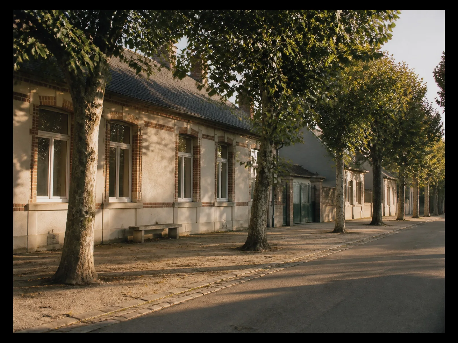 Rue calme devant une école en fin d’après-midi