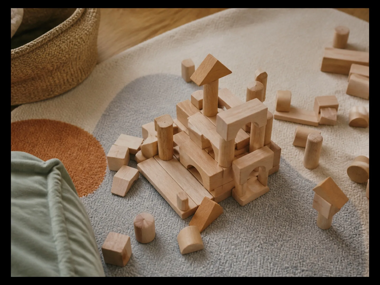 Jeu de construction en bois étalé sur un tapis