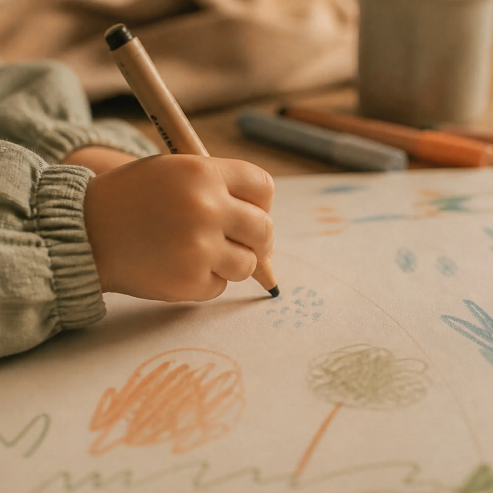 Main d’enfant tenant un feutre au-dessus d’un dessin