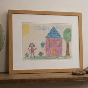 Dessin d’enfant encadré dans un bois clair