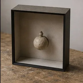 Petit objet présenté dans une boîte profonde
