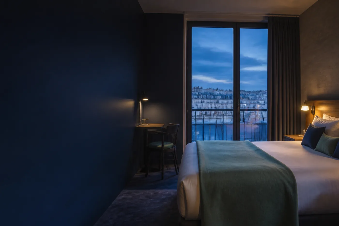 Chambre d’hôtel au crépuscule, vue sur les toits de Paris