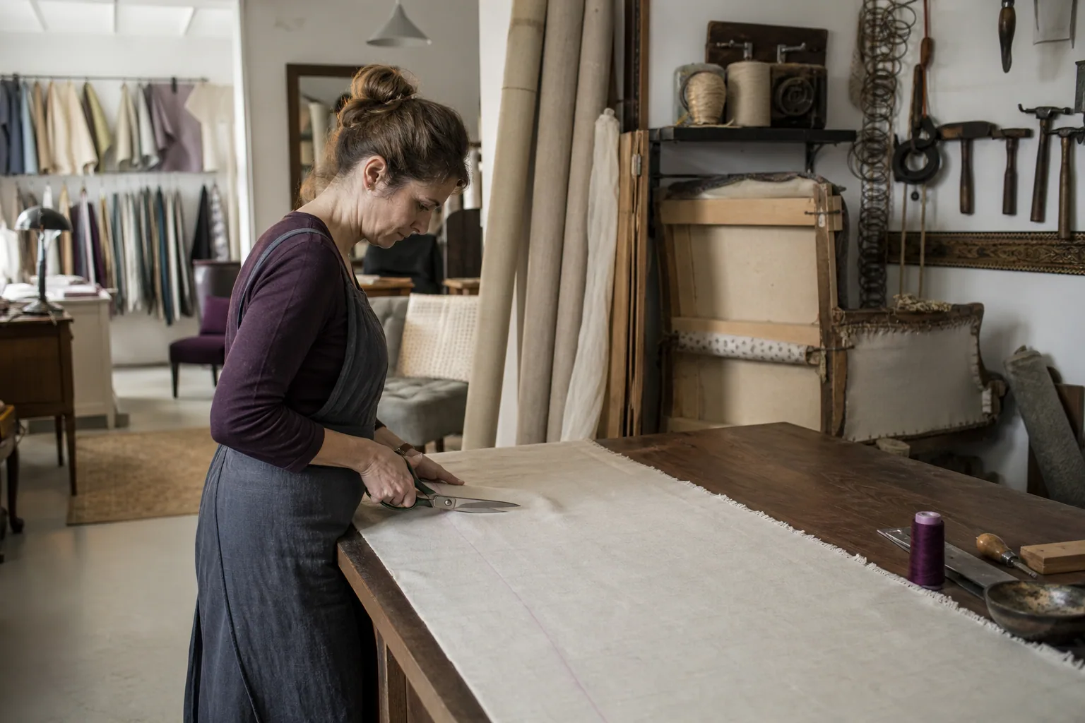 Clara Morel coupe un lin sur la grande table de l’atelier