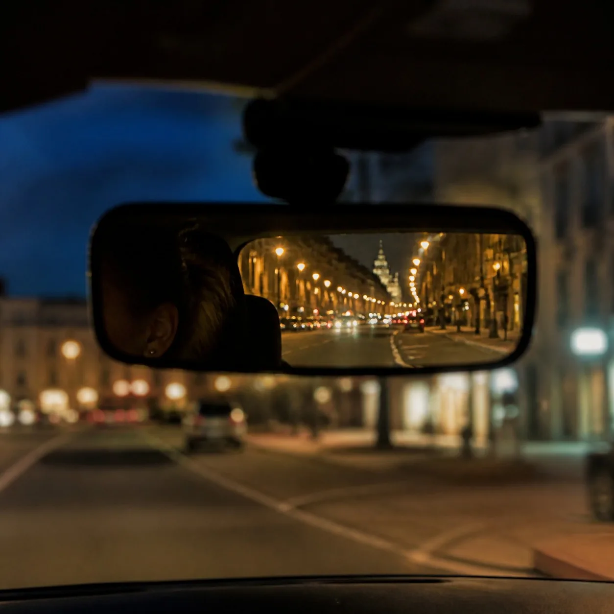 Rétroviseur intérieur de nuit, éclairages urbains en arrière-plan