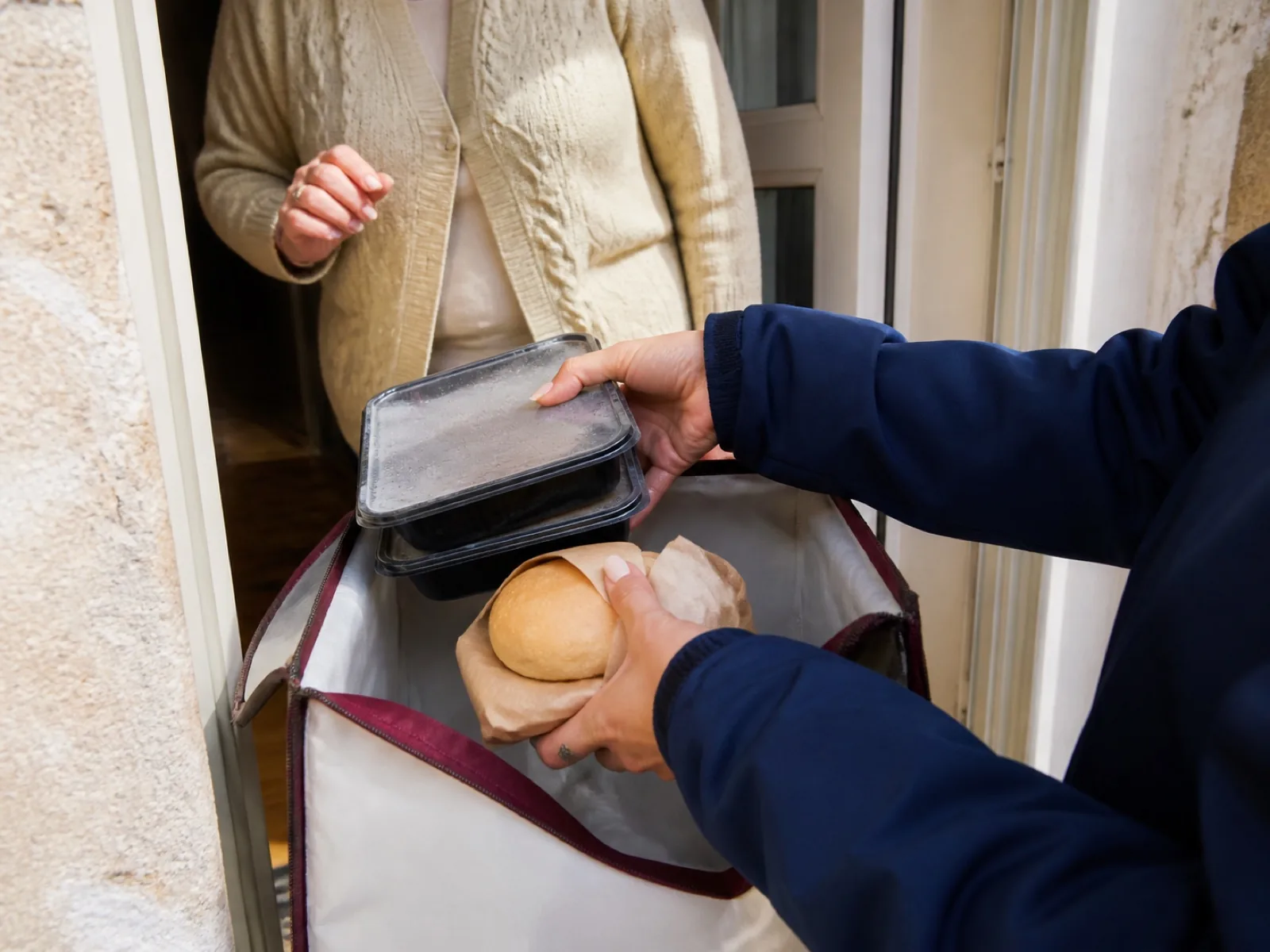 Livreuse déposant un panier au seuil d'un appartement